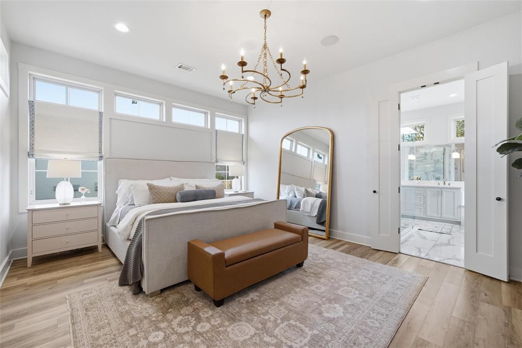 17001 Escondida Court Woodway, TX 76712 - Photo 17 of 40 a spacious bedroom with a bed and a chandelier