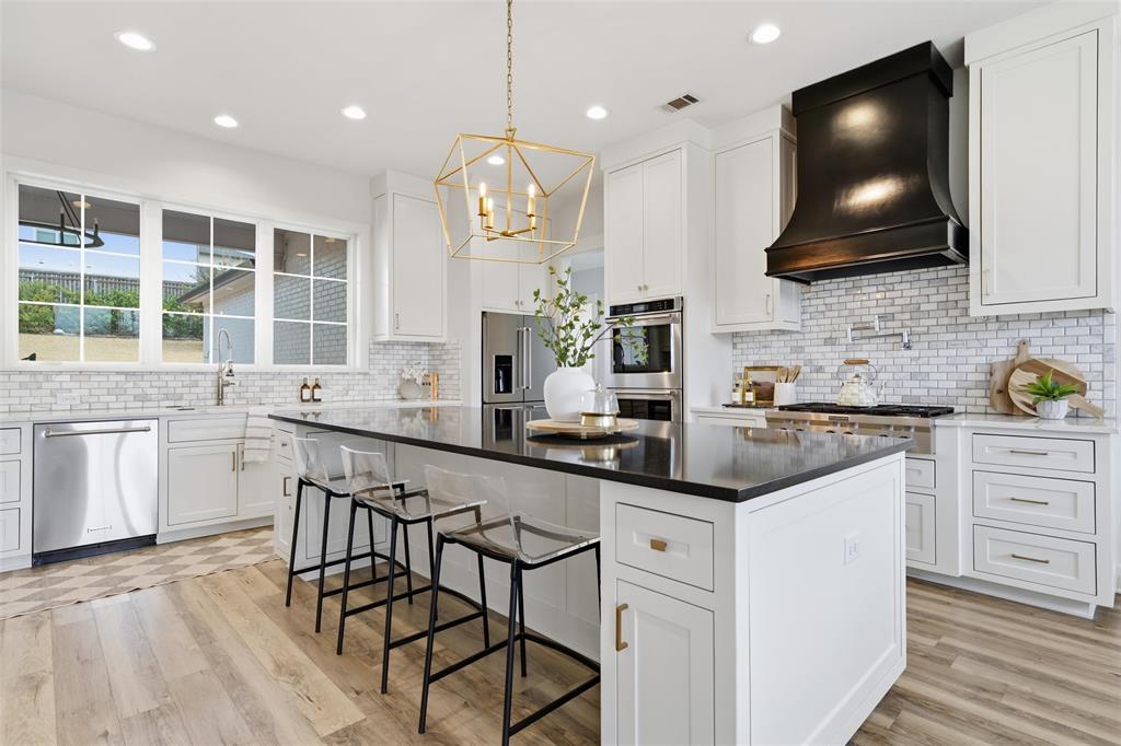 17001 Escondida Court Woodway, TX 76712 - Photo 10 of 40 a kitchen with stainless steel appliances kitchen island granite countertop a sink a stove and cabinets