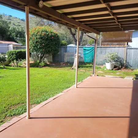 a view of a backyard with table and chairs and floor to ceiling window