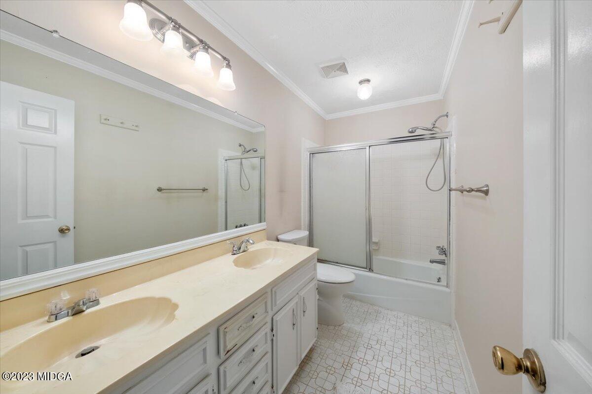 1434 Craddock Way Macon, GA 31210 - Photo 21 of 32 a bathroom with a double vanity sink toilet mirror and shower