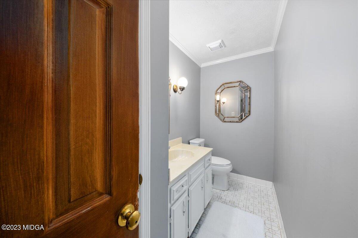 1434 Craddock Way Macon, GA 31210 - Photo 9 of 32 a bathroom with a toilet a sink and a mirror