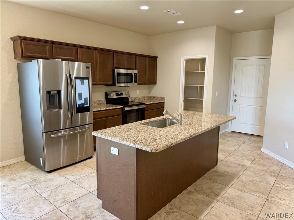5392 Rattlesnake Road Kingman, AZ 86409 - Photo 13 of 35 a kitchen with kitchen island granite countertop a refrigerator a stove a sink a microwave and island