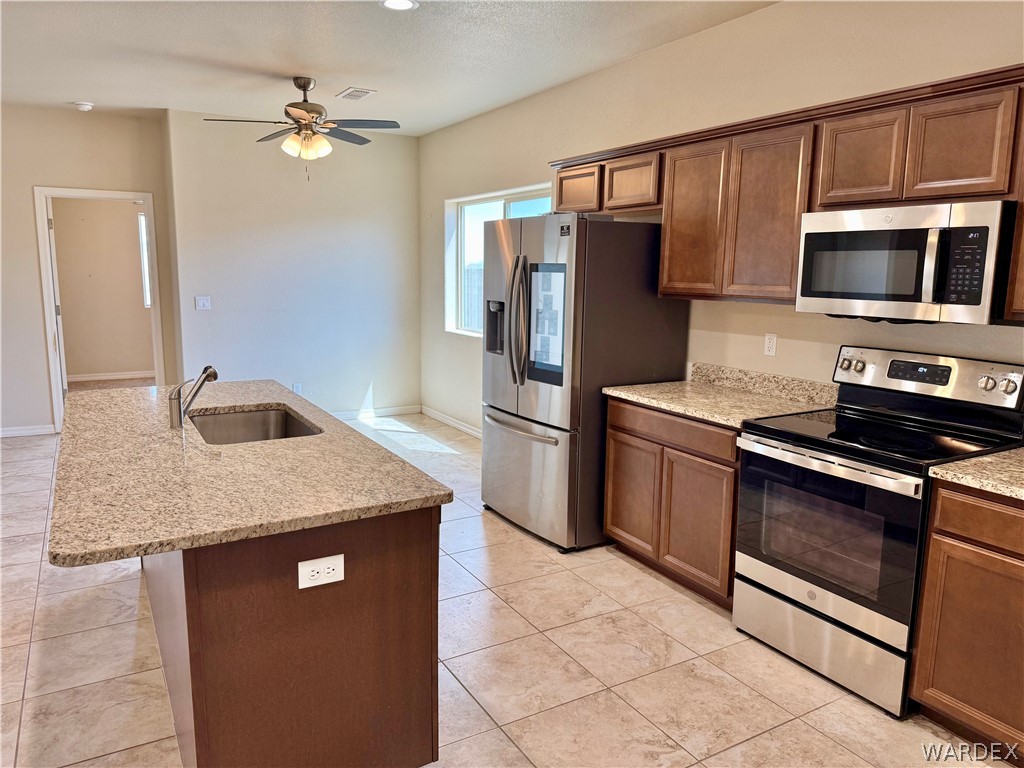 5392 Rattlesnake Road Kingman, AZ 86409 - Photo 14 of 35 a kitchen with stainless steel appliances granite countertop a refrigerator stove and microwave