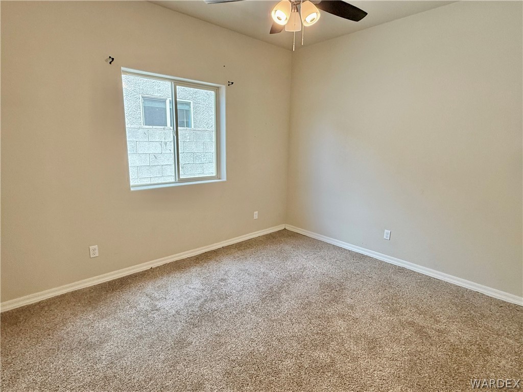 5392 Rattlesnake Road Kingman, AZ 86409 - Photo 25 of 35 an empty room with a chandelier fan