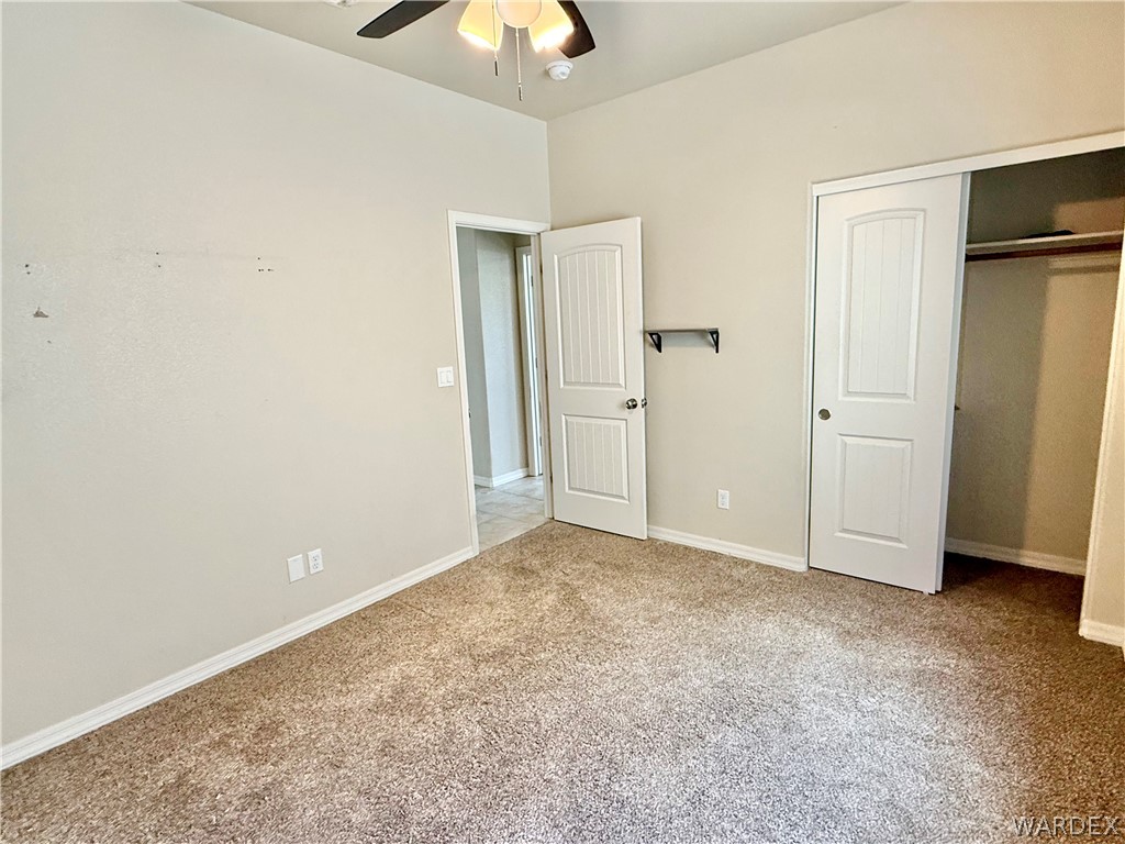 5392 Rattlesnake Road Kingman, AZ 86409 - Photo 26 of 35 an empty room with closet and chandelier fan