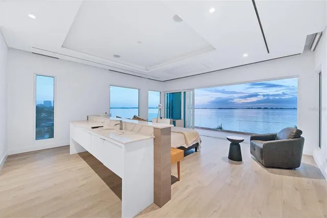 a spacious bedroom with a bed and a flat screen tv