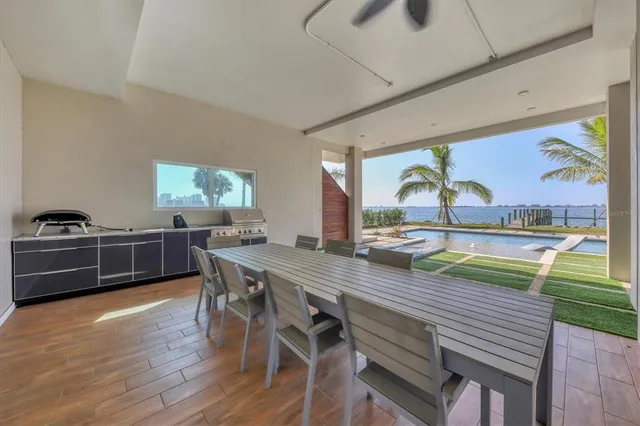 a view of small pool with lawn chairs and plants