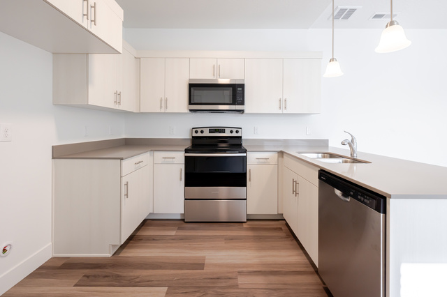 4662 Poplar Way, Unit Q301 Mapleton, UT 84664 - Photo 5 of 18 Kitchen featuring stainless steel appliances, a peninsula, light wood-type flooring, hanging light fixtures, and white cabinetry