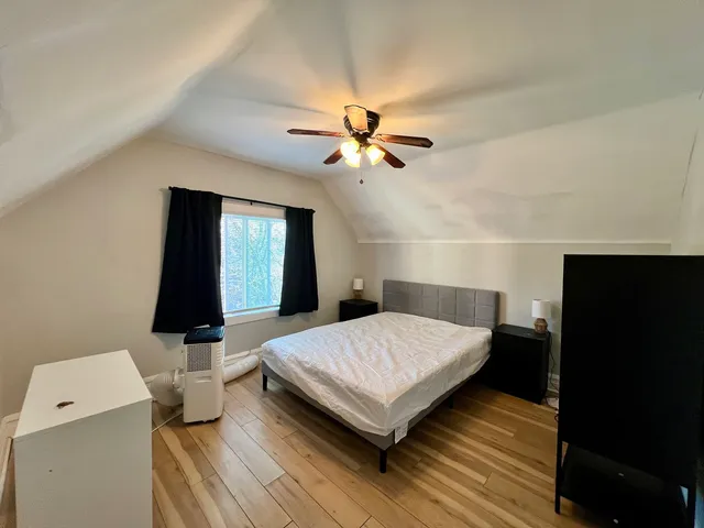 a bedroom with a bed and a flat tv screen on dresser