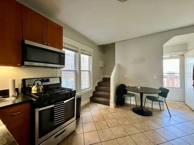 a kitchen with granite countertop a stove a sink and a microwave