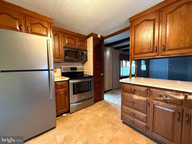 a kitchen with granite countertop stainless steel appliances and wooden cabinets