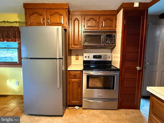 a kitchen with stainless steel appliances granite countertop a refrigerator and a stove