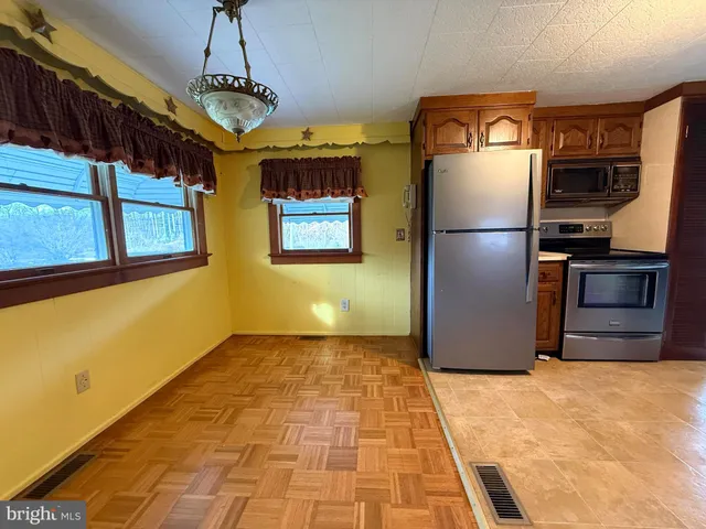a view of a refrigerator in kitchen and hallway