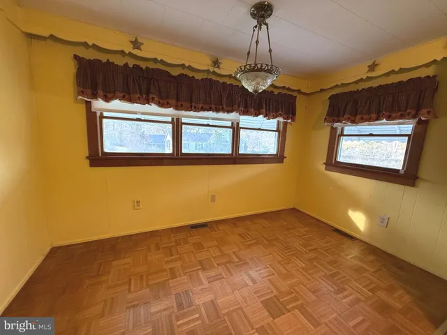 a view of a livingroom with a chandelier furniture and windows