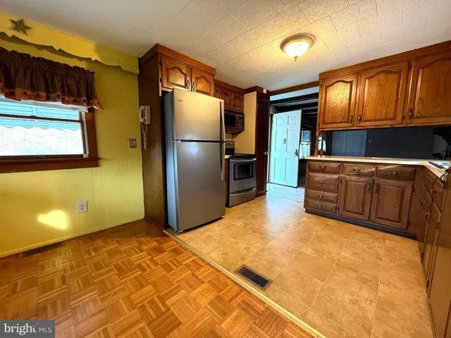 a kitchen with stainless steel appliances granite countertop a refrigerator and a stove top oven