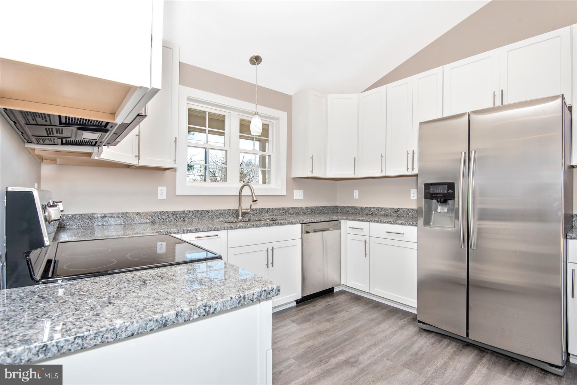 4235 Horine Road Jefferson, MD 21755 - Photo 17 of 24 a kitchen with stainless steel appliances granite countertop a refrigerator a sink a stove and white cabinets with wooden floor