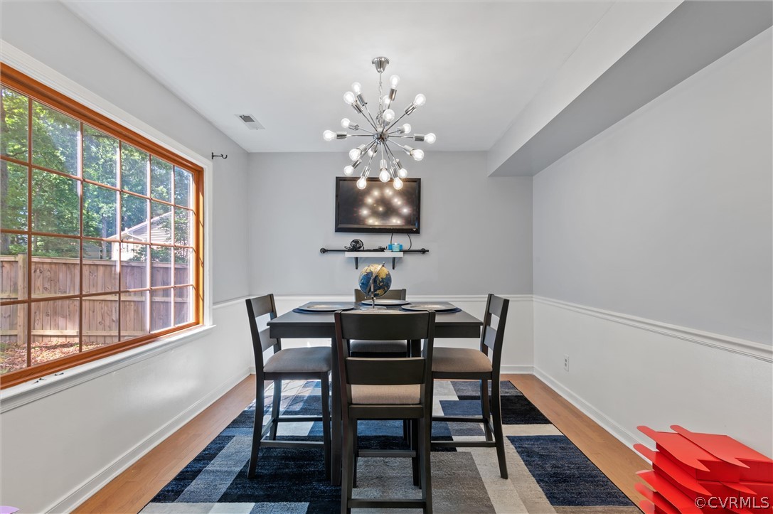 10731 Timberun Road Chesterfield, VA 23832 - Photo 15 of 25 a view of a dining room with furniture a chandelier and wooden floor