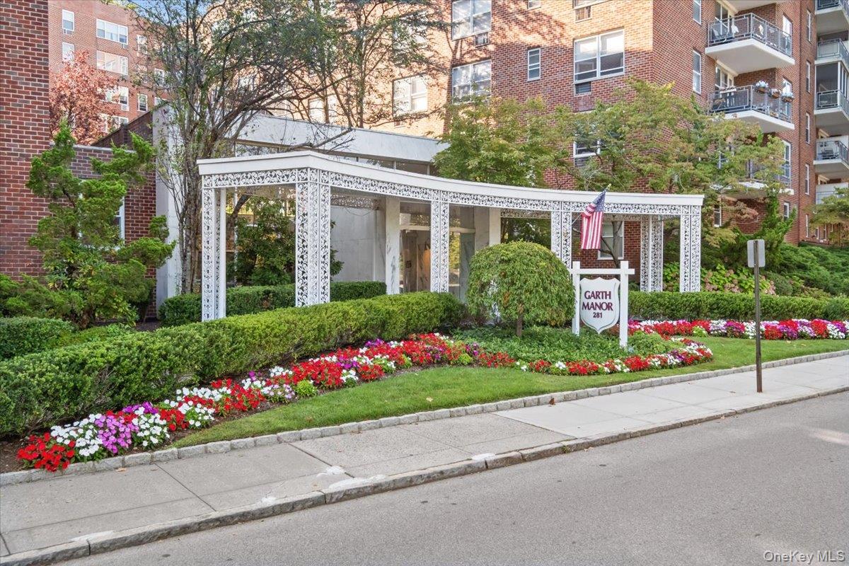 281 Garth Road, Unit C2H Scarsdale, NY 10583 - Photo 1 of 38 a house with a flower garden in front of it