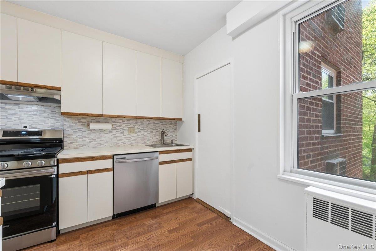 281 Garth Road, Unit C2H Scarsdale, NY 10583 - Photo 27 of 38 a kitchen with granite countertop white cabinets and stainless steel appliances