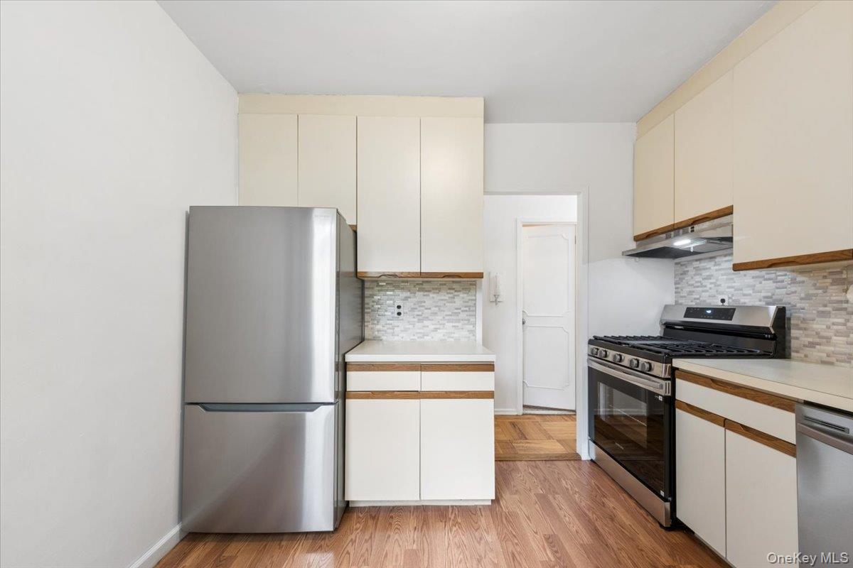281 Garth Road, Unit C2H Scarsdale, NY 10583 - Photo 30 of 38 a kitchen with a refrigerator a stove top oven and wooden floor