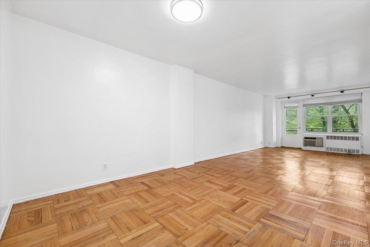 281 Garth Road, Unit C2H Scarsdale, NY 10583 - Photo 8 of 38 a view of empty room with wooden floor and fan