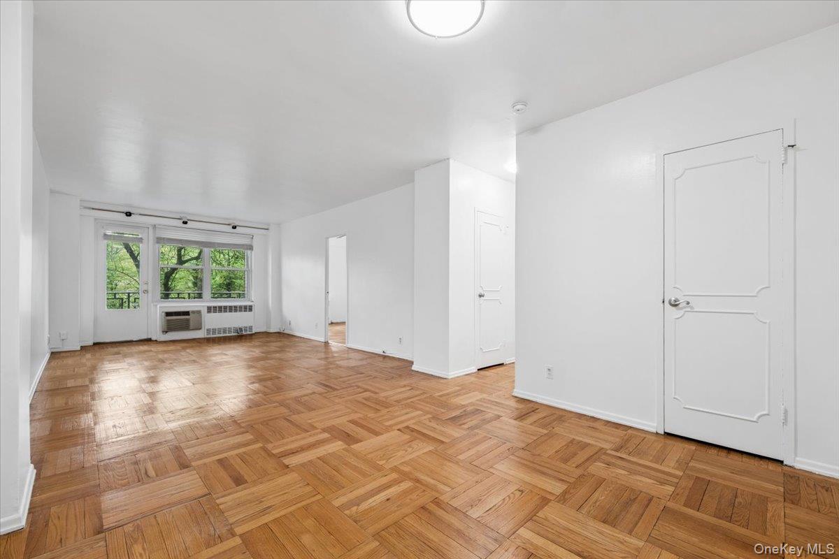 281 Garth Road, Unit C2H Scarsdale, NY 10583 - Photo 10 of 38 a view of an empty room with wooden floor and a window