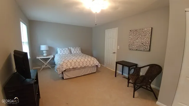 a bedroom with a bed chair and a lamp