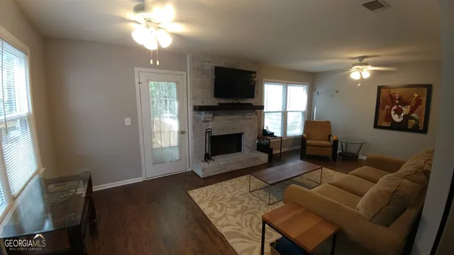 a living room with furniture a flat screen tv and a fireplace