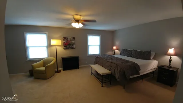 a spacious bedroom with a bed and a chandelier