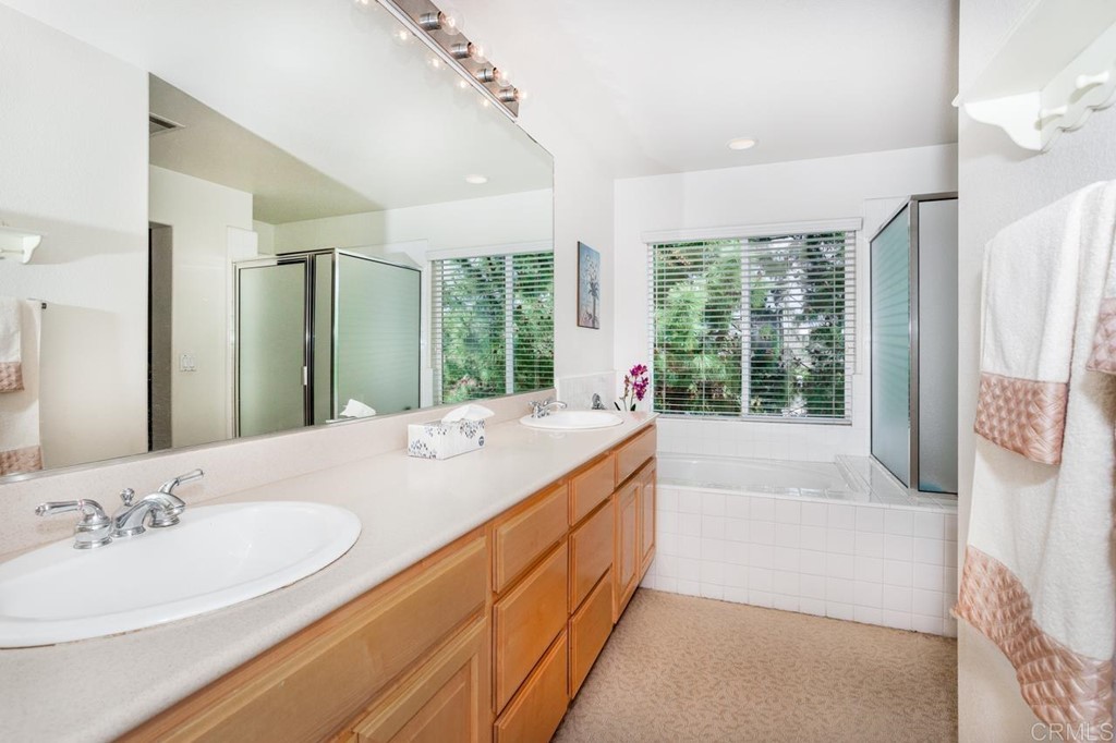 5560 Foxtail Loop Carlsbad, CA 92010 - Photo 16 of 32 a spacious bathroom with a granite countertop sink and a large mirror