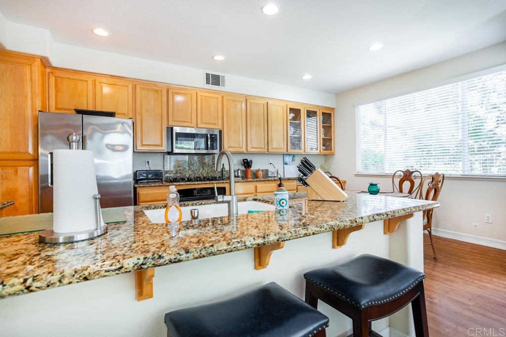 5560 Foxtail Loop Carlsbad, CA 92010 - Photo 5 of 32 a kitchen with stainless steel appliances granite countertop a stove a sink and a refrigerator