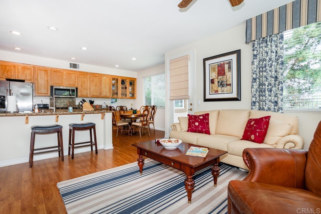 5560 Foxtail Loop Carlsbad, CA 92010 - Photo 10 of 32 a living room with furniture kitchen view and a wooden floor