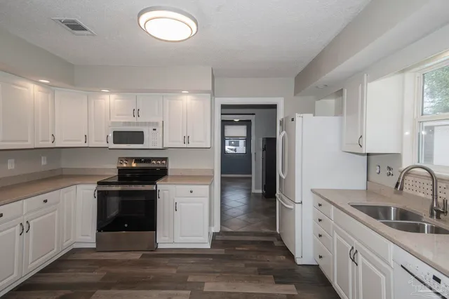 a kitchen with white cabinets and stainless steel appliances