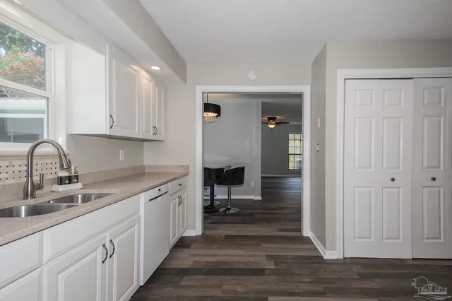 a kitchen with a sink cabinets and wooden floor