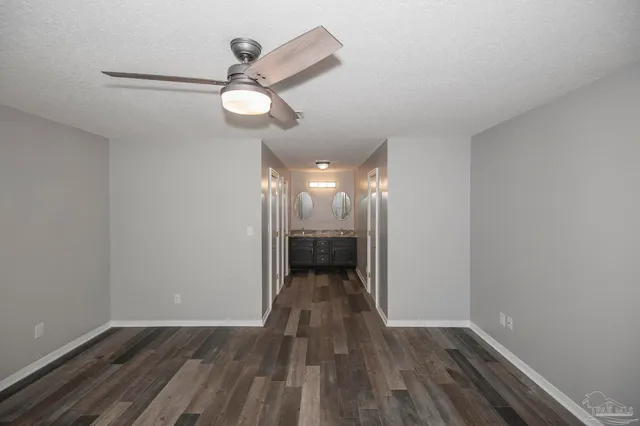 a view of a hallway with wooden floor and a chandelier