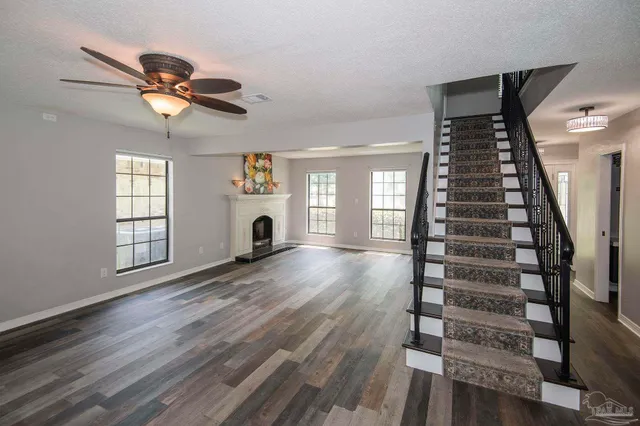 a view of empty room with stairs and wooden floor