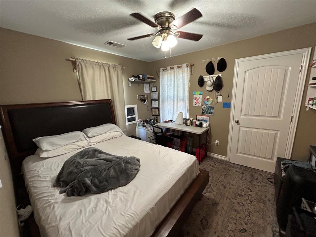 3702 Frank Street Dallas, TX 75210 - Photo 4 of 8 a bedroom with a bed and a chandelier