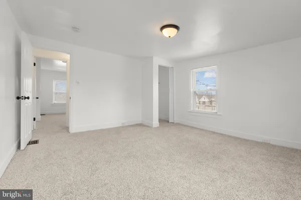an empty room with a bathroom and a sink