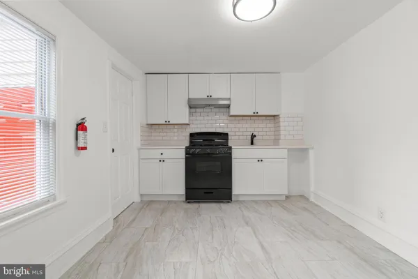 a kitchen with a stove cabinets and a wooden floor