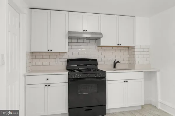 a kitchen with granite countertop white cabinets and stainless steel appliances