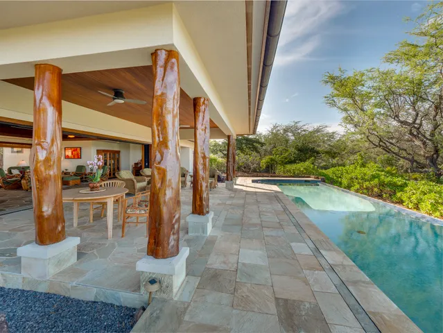a view of a porch with chairs and potted plants