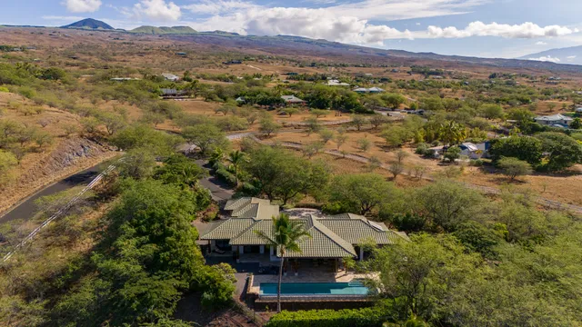 an aerial view of a house with a mountain