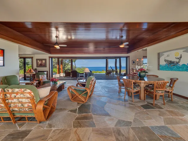 a room with lots of tables a chandelier and pool view