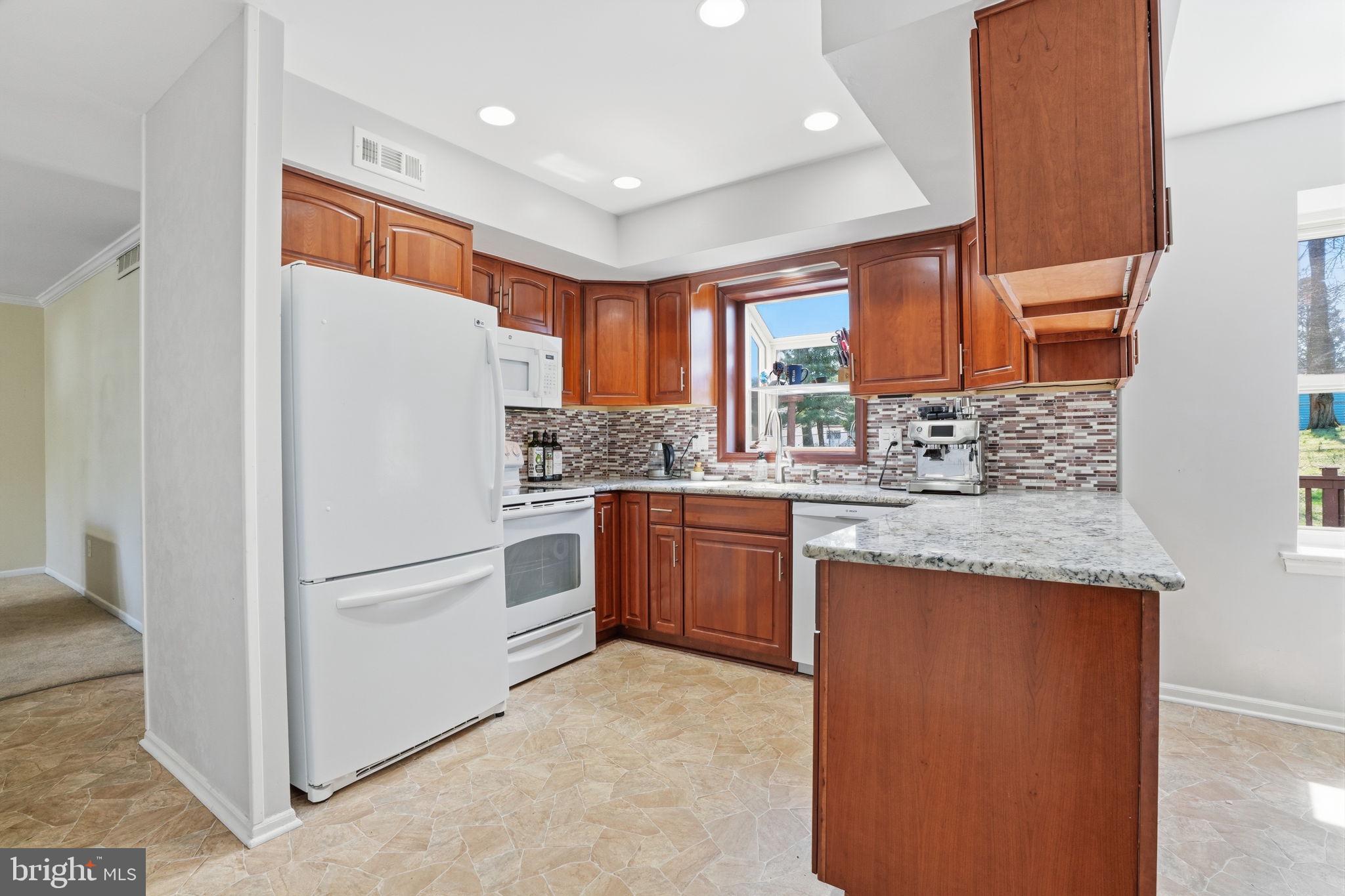 739 Bridgeview Road Feasterville-Trevose, PA 19053 - Photo 11 of 46 a kitchen with granite countertop appliances a sink and a refrigerator