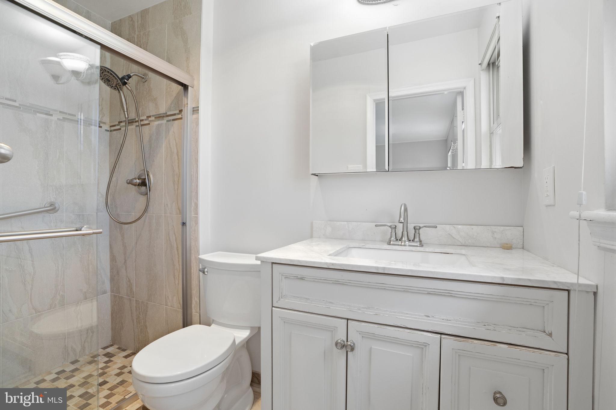 739 Bridgeview Road Feasterville-Trevose, PA 19053 - Photo 25 of 46 a bathroom with a granite countertop sink toilet a mirror and shower