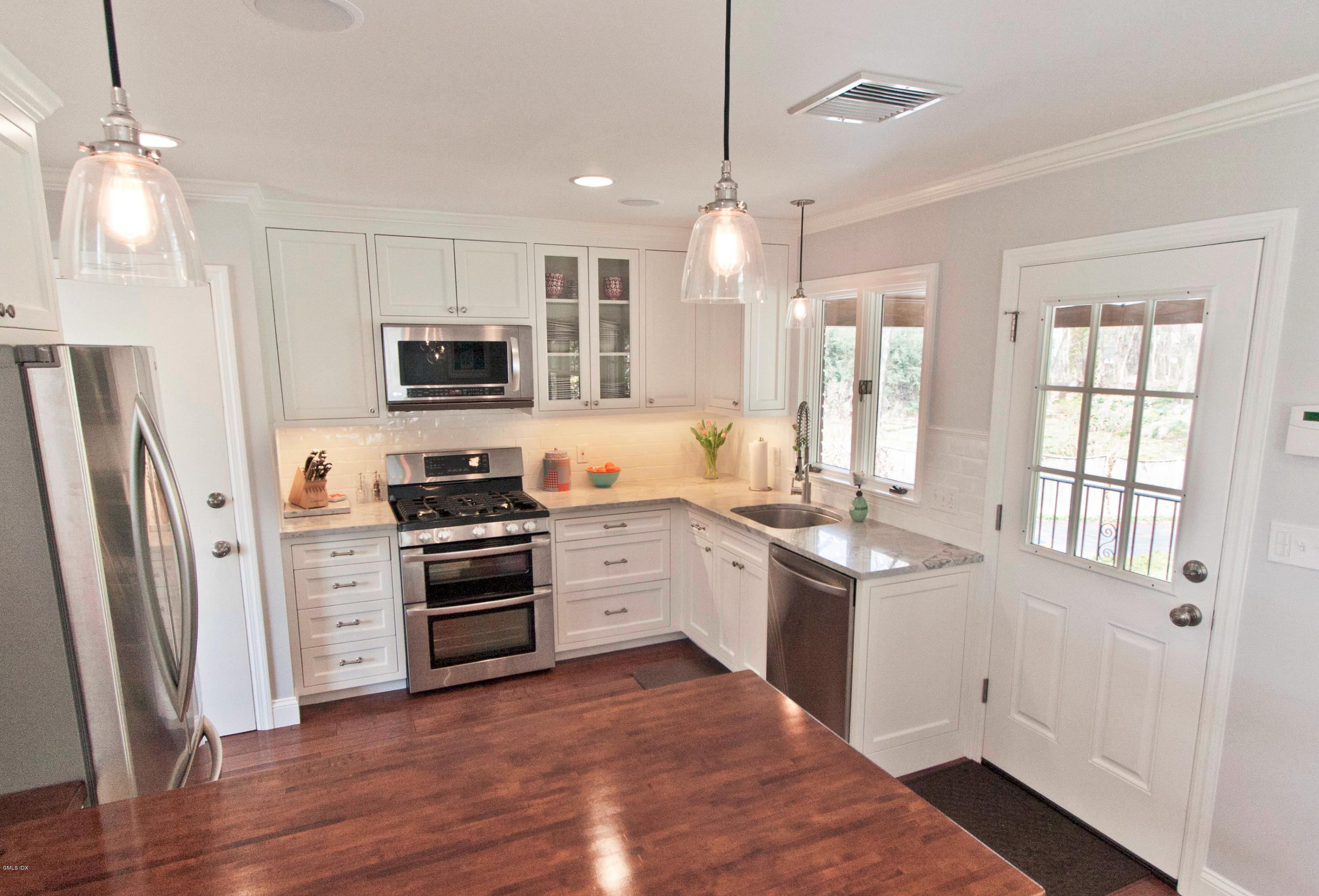 41 Indian Field Road Greenwich, CT 06830 - Photo 7 of 20 a kitchen with stainless steel appliances a stove a sink a refrigerator a microwave a sink and wooden floor