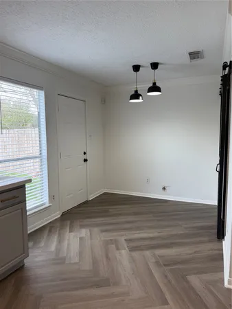 a view of room with wooden floor and windows