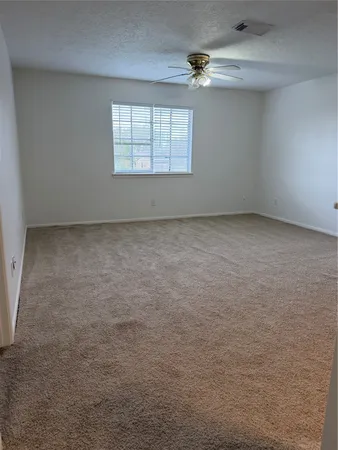 an empty room with a window and a ceiling fan