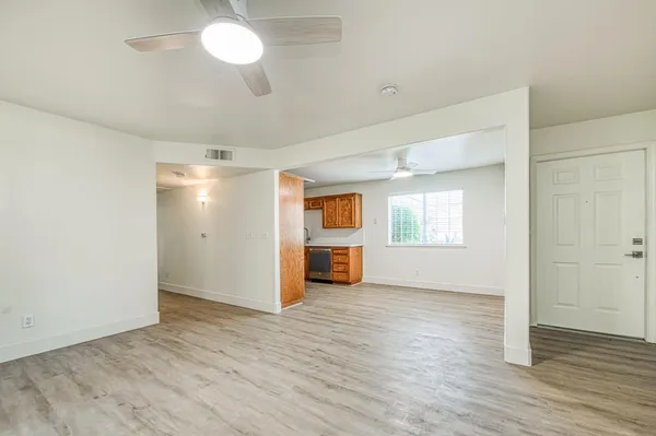 an empty room with wooden floor and windows
