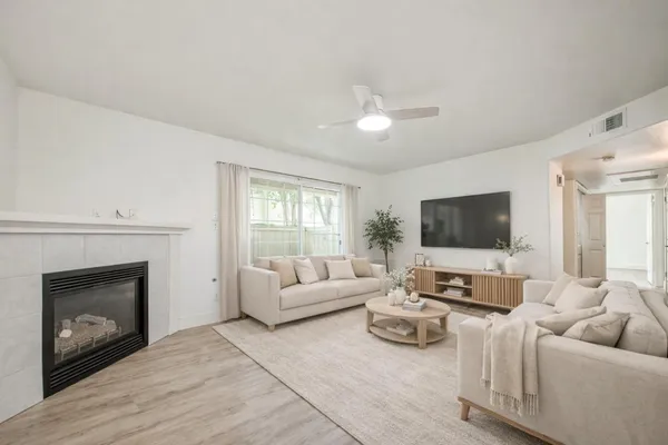 a living room with furniture a fireplace and a flat screen tv